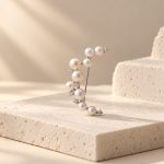 Silver-toned crescent moon brooch with graduated pearl details and small sparkling accents