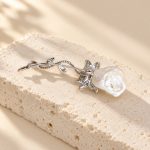 Back of baroque pearl floral brooch showing its pin fastening and curved silver-toned stem