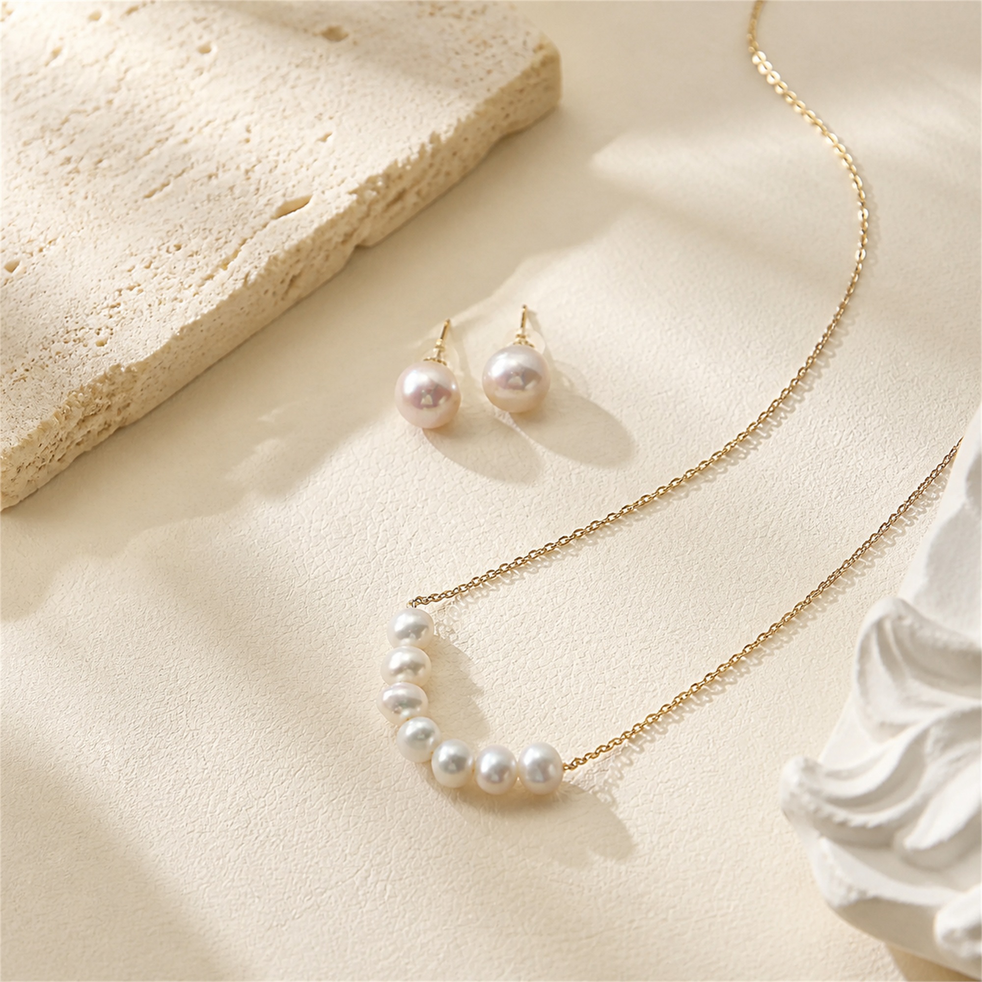 Seven-pearl necklace with matching pearl stud earrings laid flat