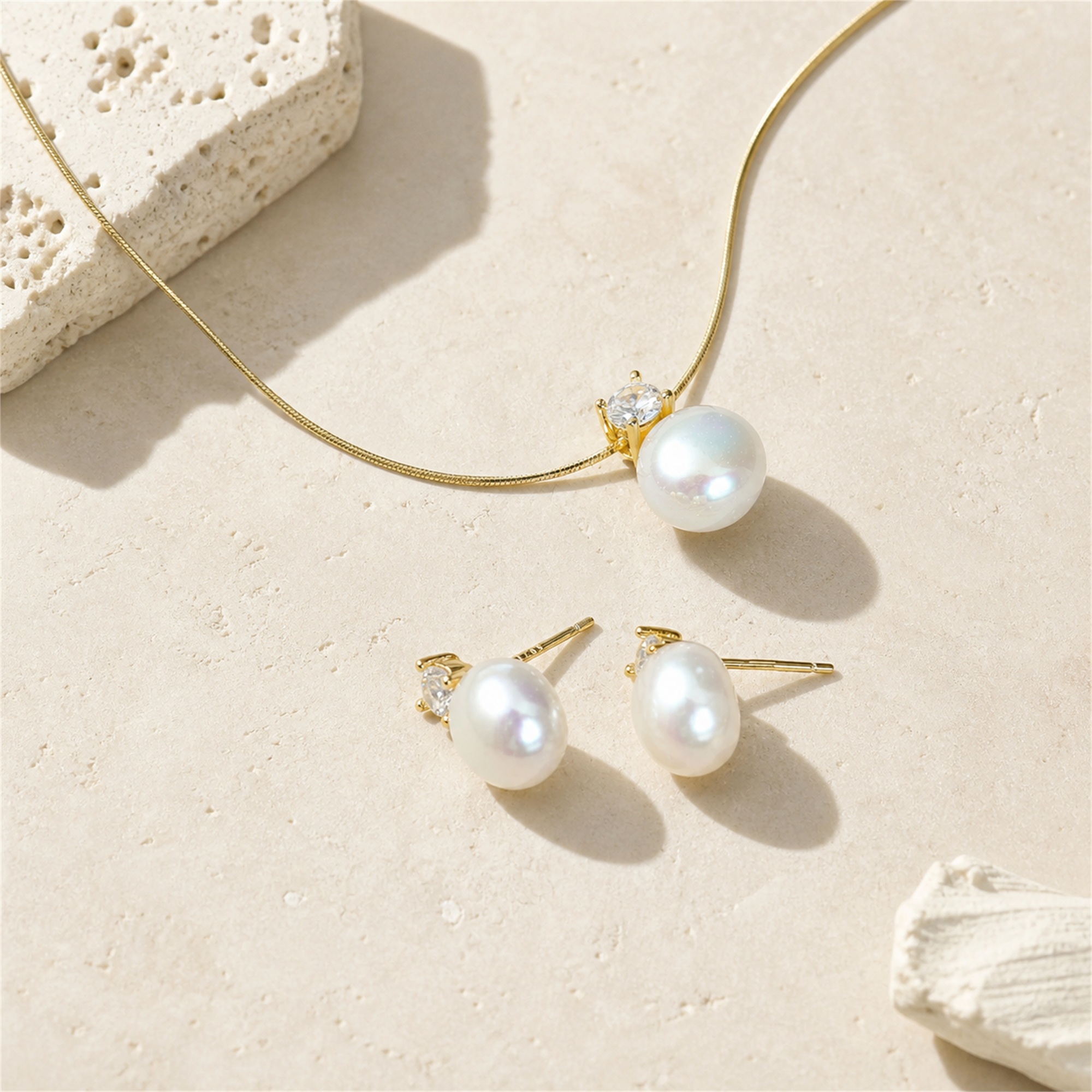 Gold-toned freshwater pearl pendant necklace and matching pearl studs laid flat