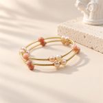 Orange moonstone and freshwater pearl multi-band bangle viewed from the side