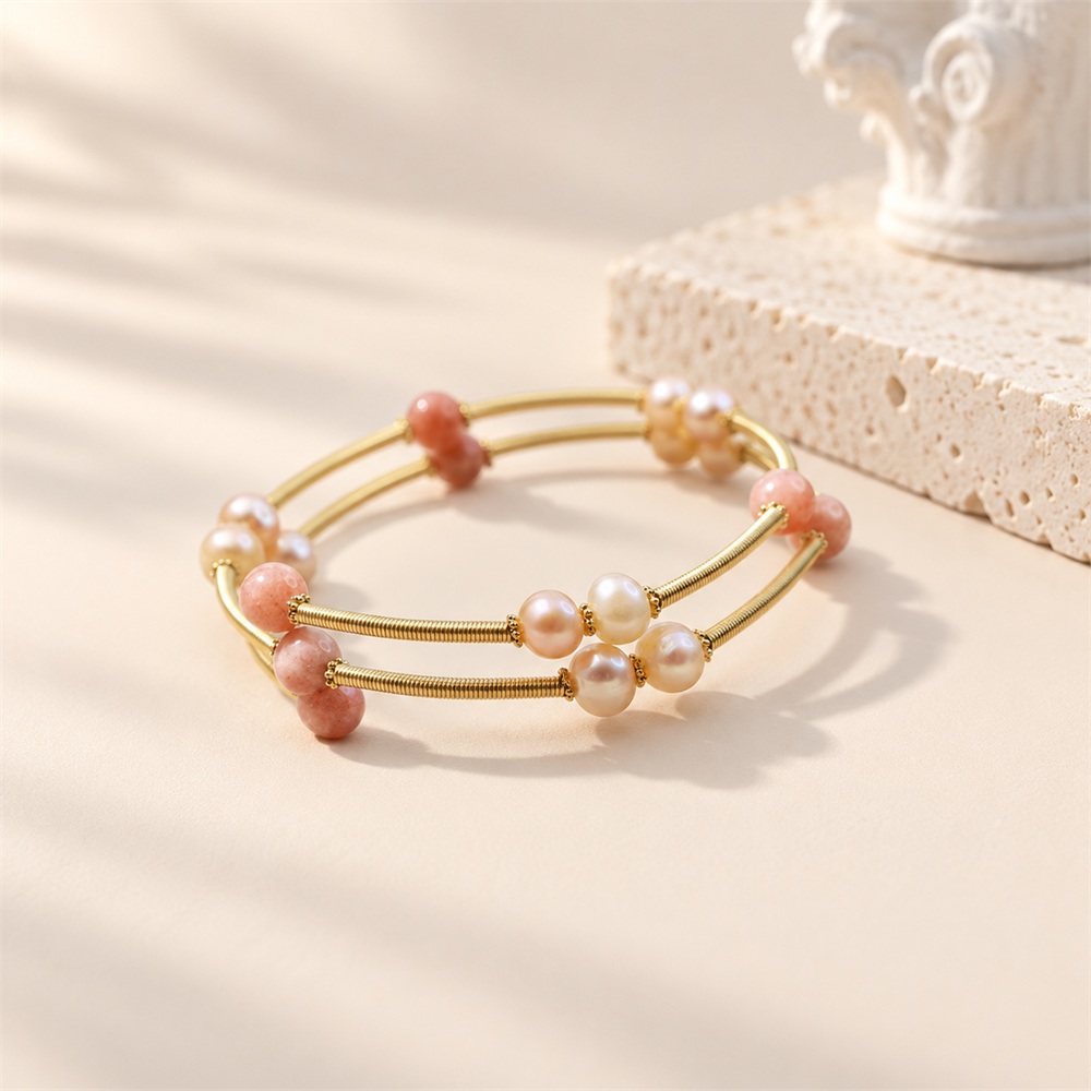 Orange moonstone and freshwater pearl multi-band bangle viewed from the side