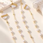 Close view of a long freshwater pearl necklace with linked pearls and gold-tone bands across large baroque pearls