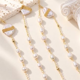 Close view of a long freshwater pearl necklace with linked pearls and gold-tone bands across large baroque pearls