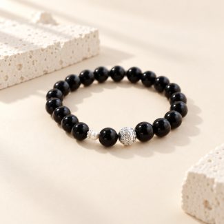 Black obsidian stretch bracelet with a small freshwater pearl and decorative silver-tone bead