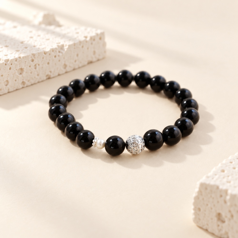 Black obsidian stretch bracelet with a small freshwater pearl and decorative silver-tone bead