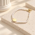 Reverse side of the round gold-tone bezel on a fine freshwater pearl bracelet