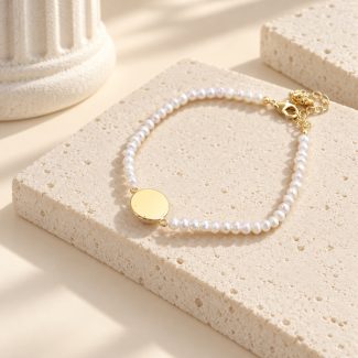 Reverse side of the round gold-tone bezel on a fine freshwater pearl bracelet