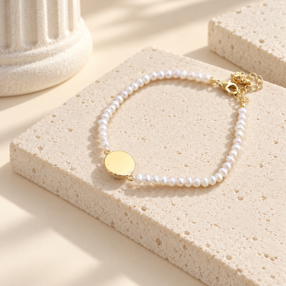 Reverse side of the round gold-tone bezel on a fine freshwater pearl bracelet