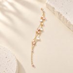 Blush and white baroque pearl bracelet with three fine gold-tone chains laid out at full length