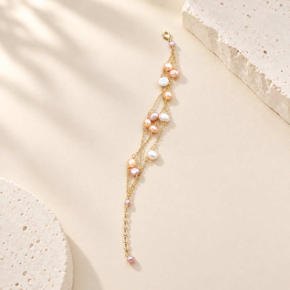 Blush and white baroque pearl bracelet with three fine gold-tone chains laid out at full length