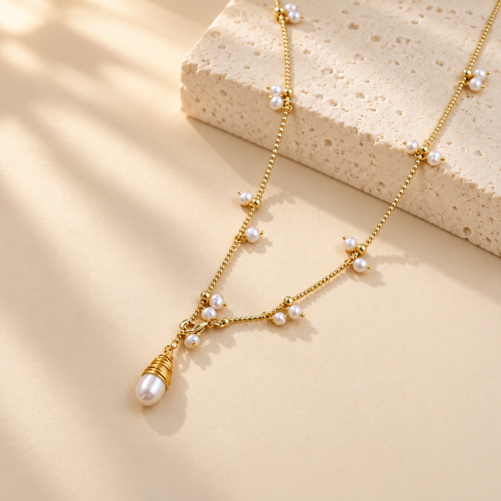 Close-up of a freshwater pearl fringe necklace with a wire-wrapped pearl pendant and front clasp