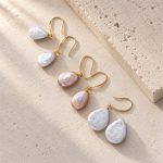 White and peach pearl drop earrings in oval and teardrop shapes with gold-toned hooks