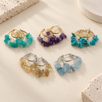 Five colourways of gemstone chip double hoop earrings arranged together on stone