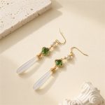 Pair of green clover earrings with pearl accents and long white jade drops laid flat