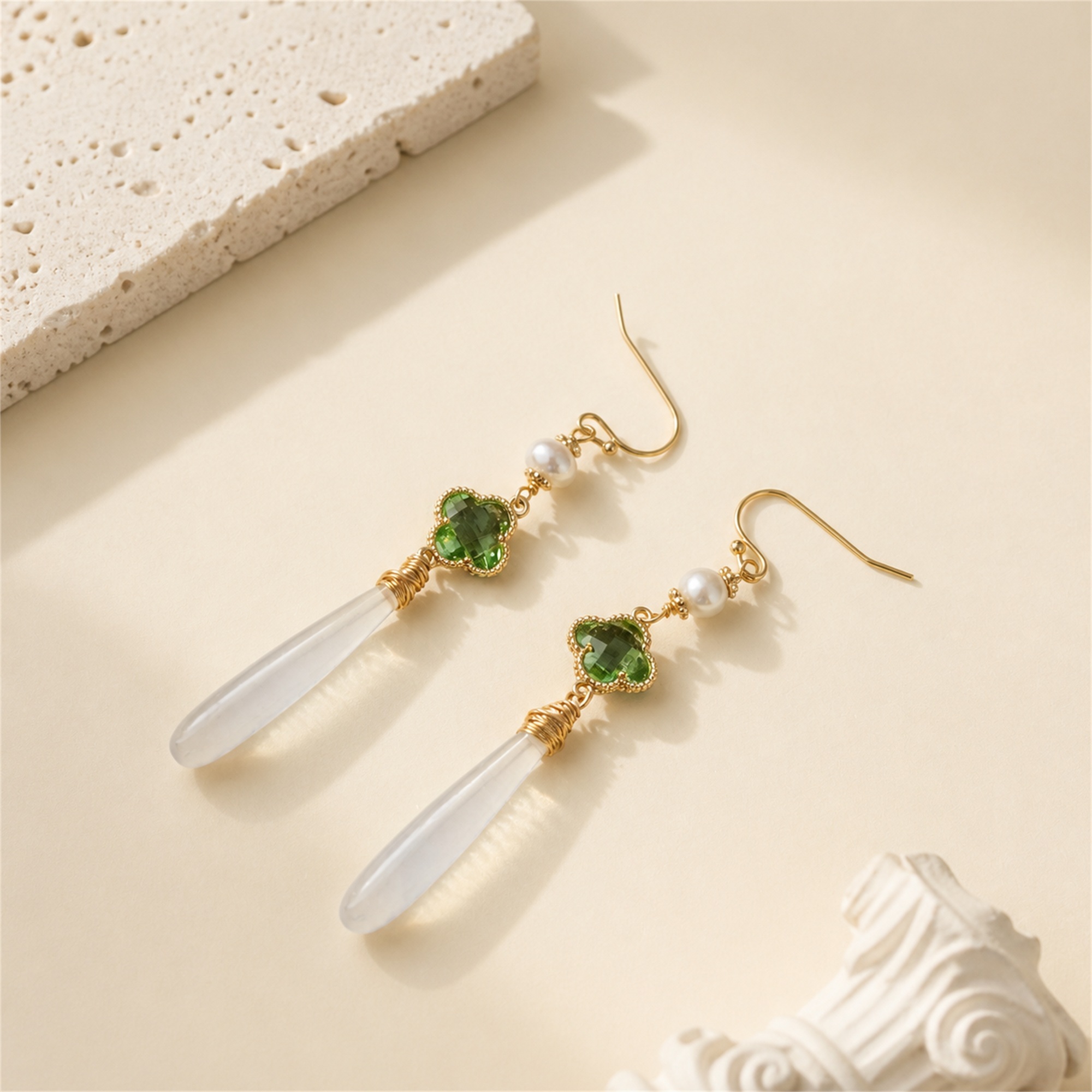 Pair of green clover earrings with pearl accents and long white jade drops laid flat