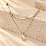 Silver-tone stick pearl collar and baroque pearl pendant necklace worn together