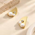 Half-moon gold-tone stud earrings with two pearls and a crystal seen from an angle