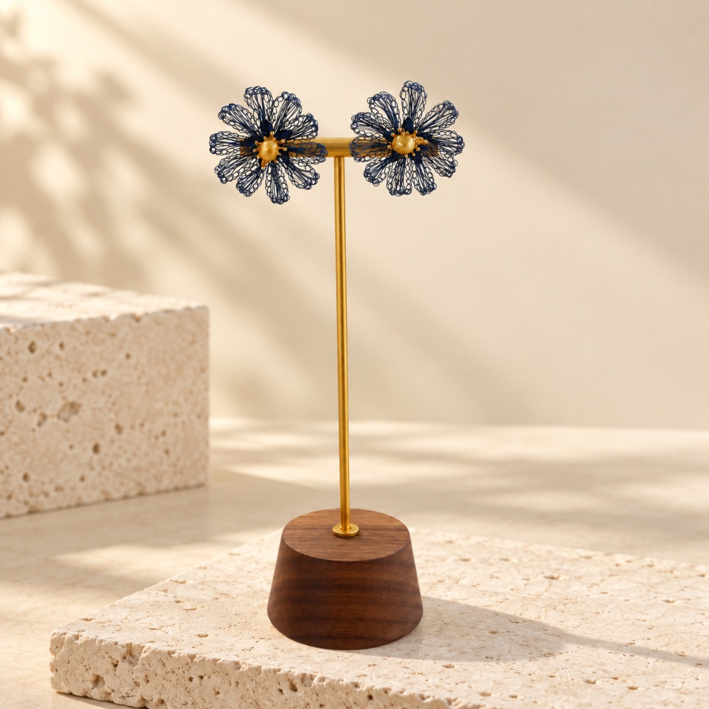 Pair of blue wire crochet pearl daisy studs on a display stand