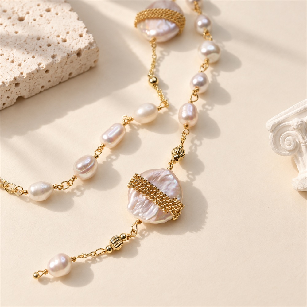Detail of gold-tone banded baroque pearls and hand-linked freshwater pearls on a long necklace