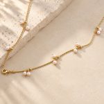 Fine golden necklace chain with clusters of tiny freshwater pearls and a lobster clasp