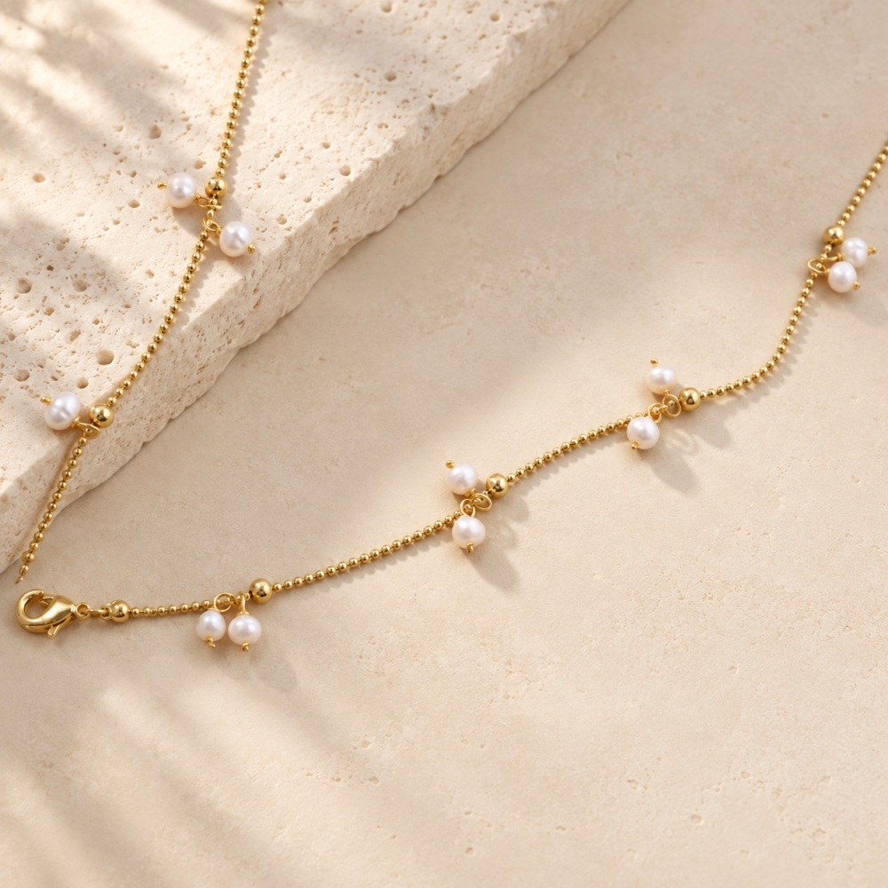 Fine golden necklace chain with clusters of tiny freshwater pearls and a lobster clasp
