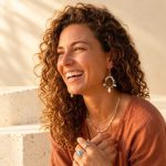 Blue crystal and pearl teardrop earrings worn to show their hanging silhouette