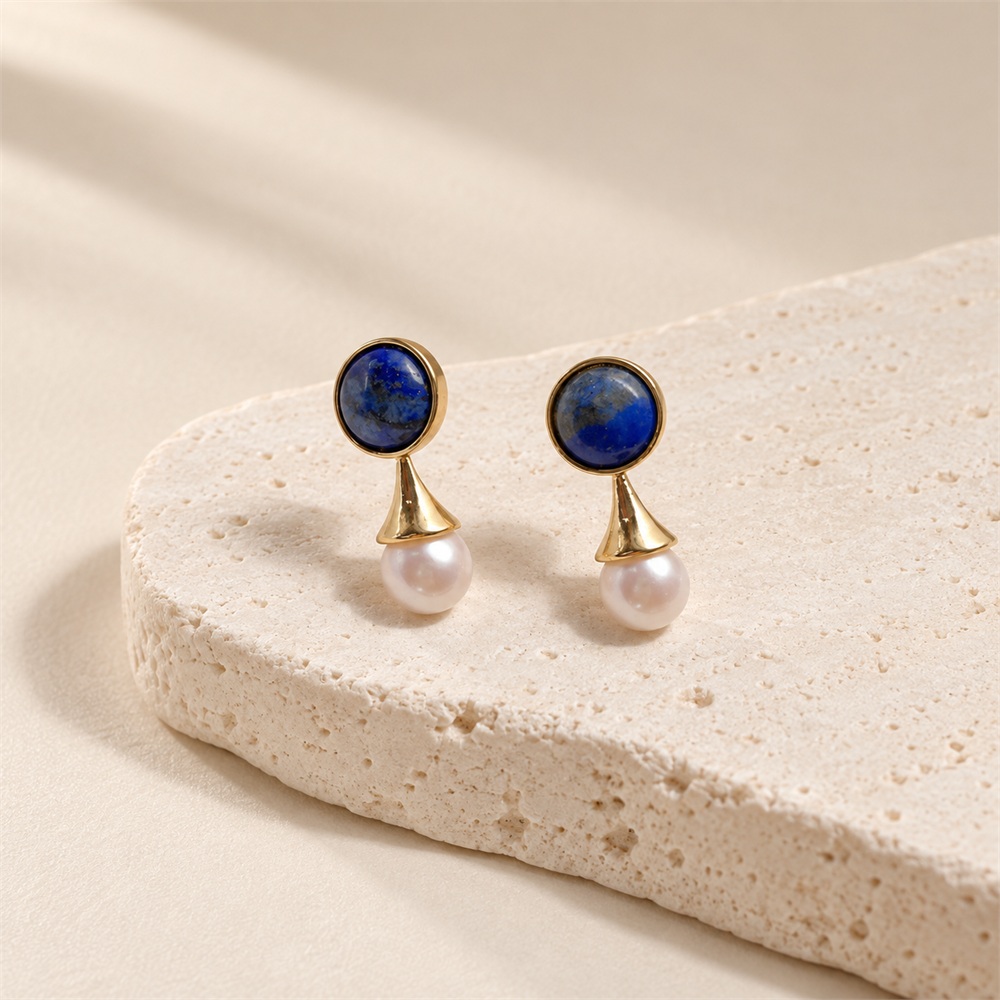Angled view of lapis lazuli pearl earrings showing gold-toned flared connections