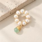 Angled view of pearl circle brooch with dangling green jade bead