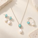 Close view of silver-tone turquoise pearl necklace, earrings and open ring