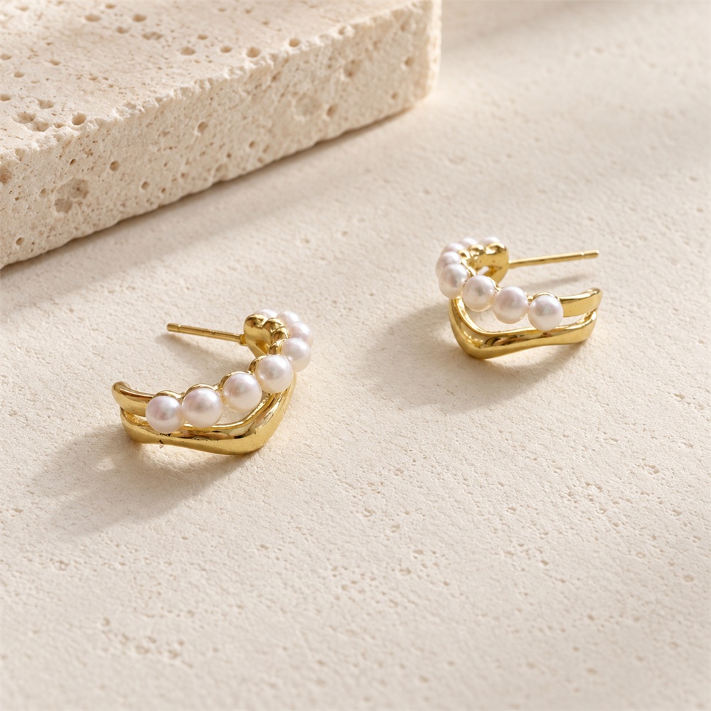 Angled view of two-tier freshwater pearl crescent stud hoop earrings