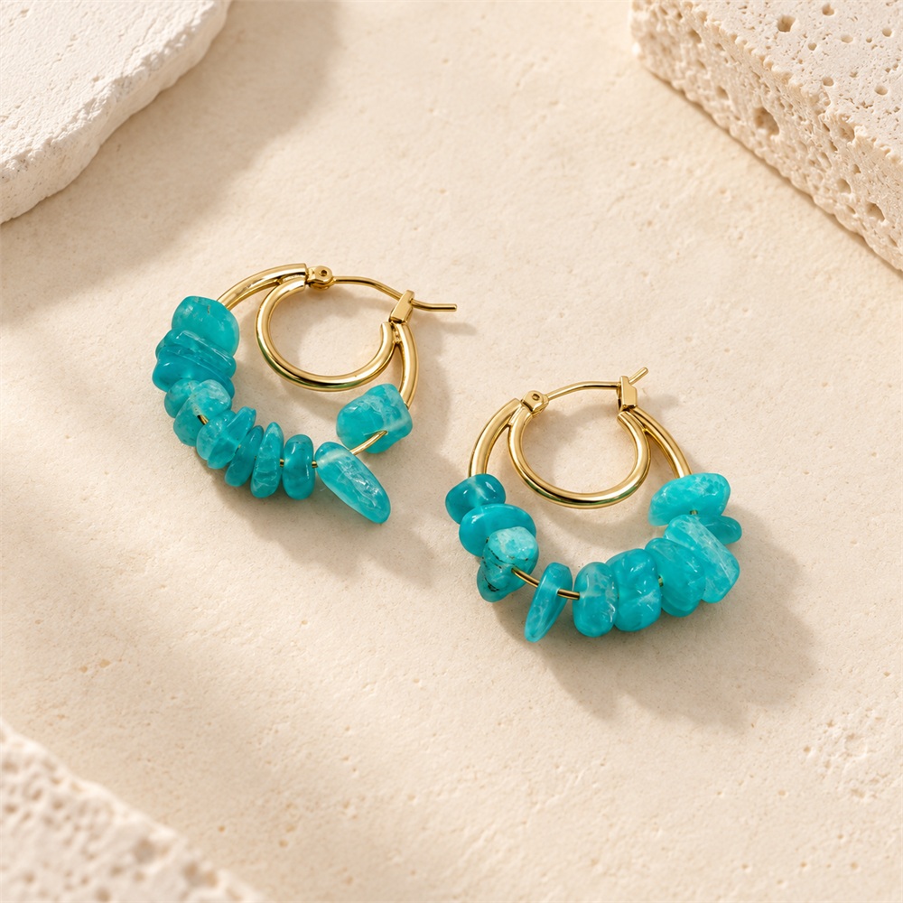 Close view of green gemstone chips on gold-tone double hoop earrings