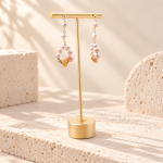 Pink agate and freshwater pearl wreath earrings hanging on a display stand