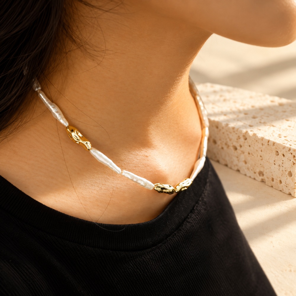 Gold-tone stick pearl collar necklace worn close to the neck