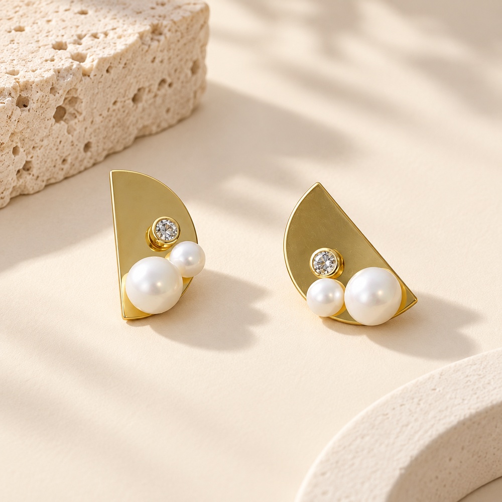 Upright front view of gold-tone half-moon pearl and crystal stud earrings