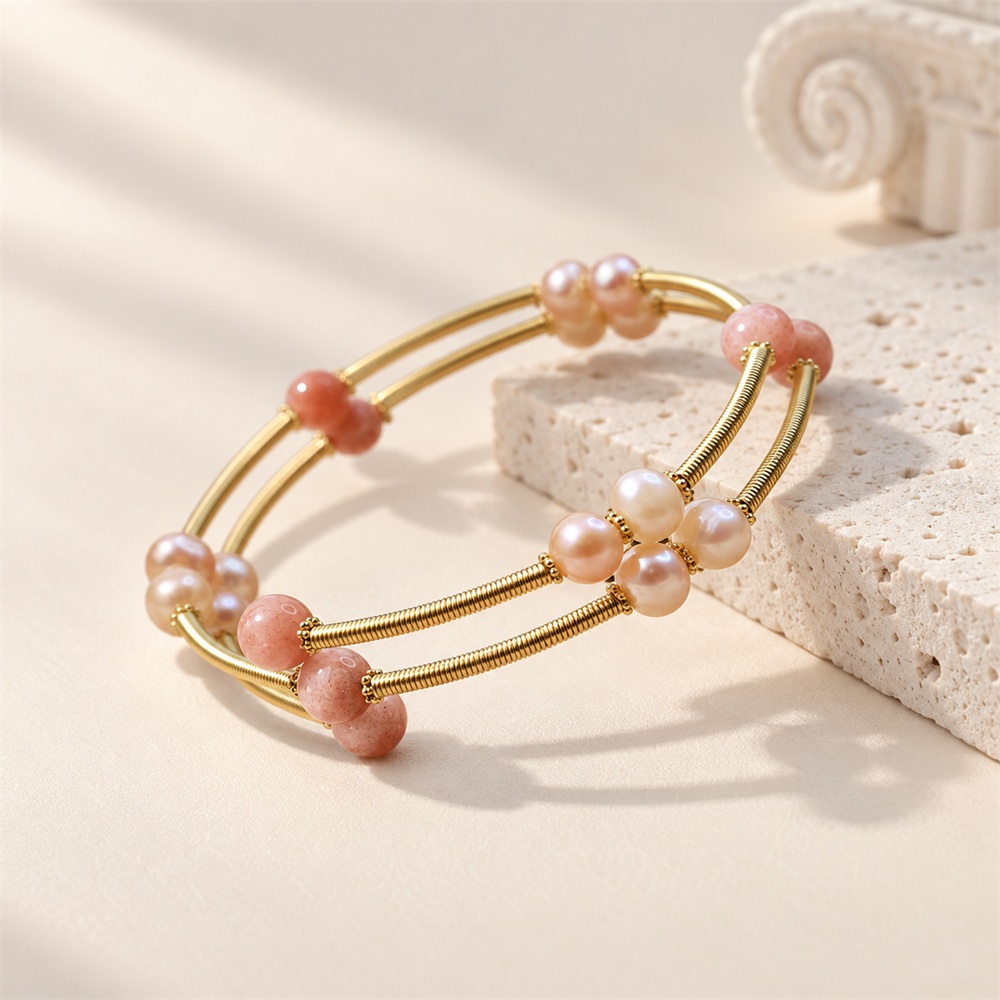 Open gold-tone multi-band bangle with orange moonstone and pearl clusters