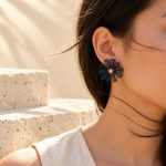 Model wearing a blue crocheted wire daisy stud earring
