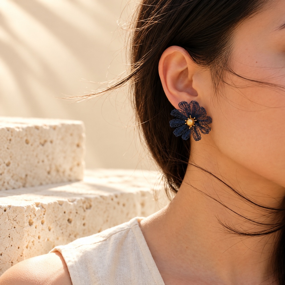 Model wearing a blue crocheted wire daisy stud earring