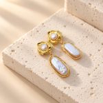 Close-up of irregular baroque pearl drops beneath textured golden stud settings