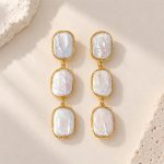 Front view of triple-drop earrings with three rectangular baroque pearls in golden wire frames