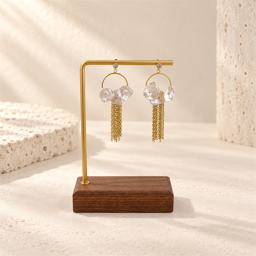 Petal pearl circle earrings with gold-tone chain fringe hanging on a display stand