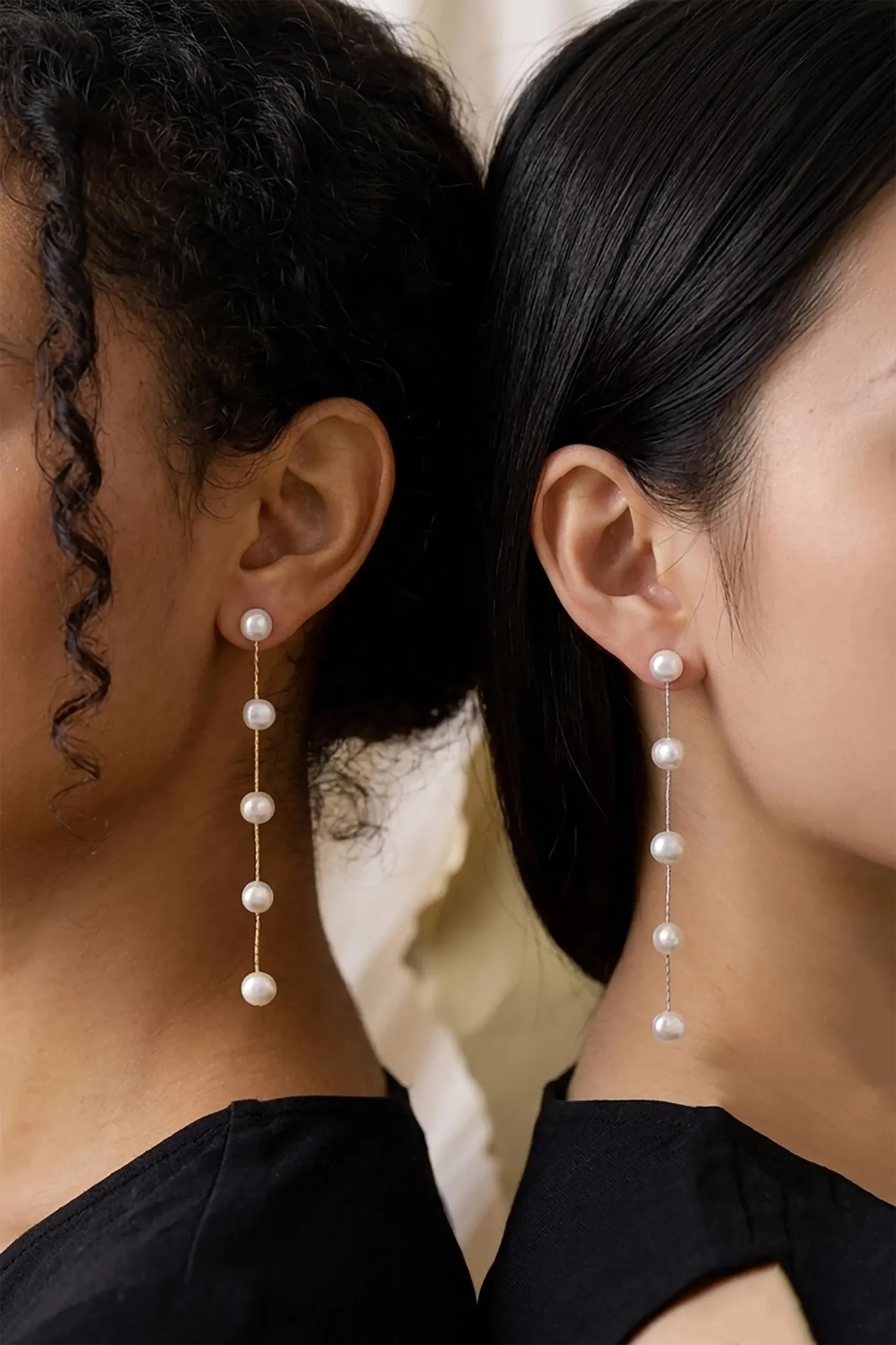 Two models wearing five-pearl long linear drop earrings in different metal tones