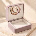 Amethyst and freshwater pearl hoop earrings displayed in an open mauve jewellery box