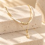 Gold-tone stick pearl collar and baroque pearl pendant necklace layered together