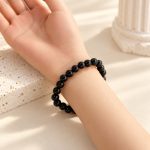 Black obsidian bead bracelet worn on a wrist