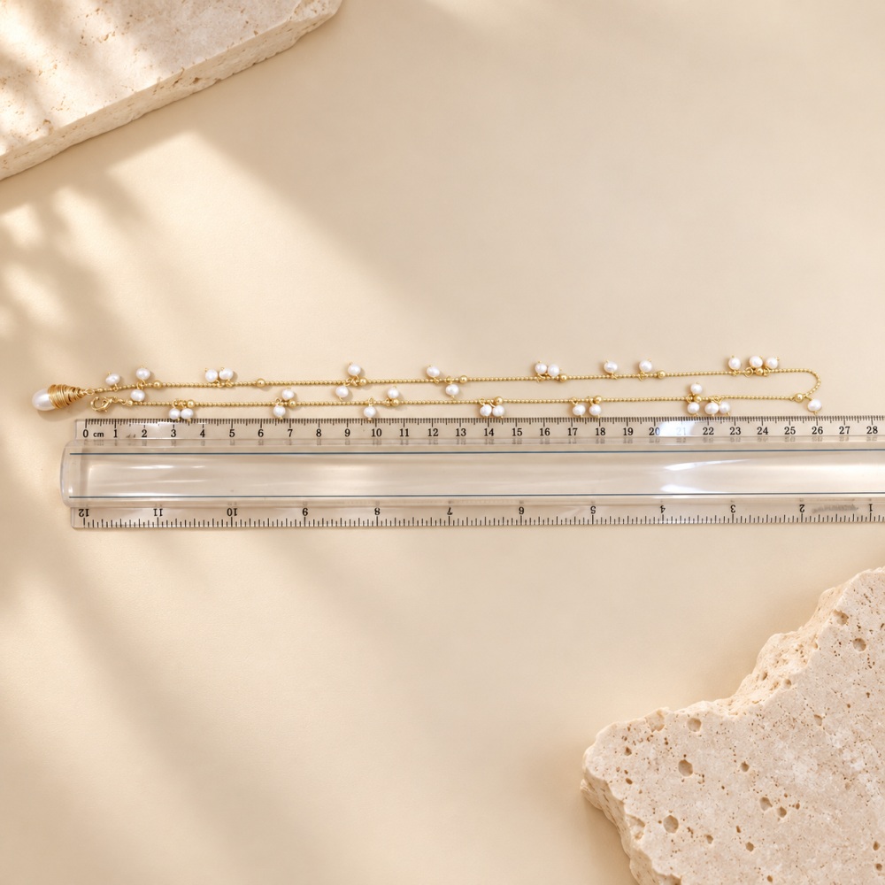 Freshwater pearl fringe necklace laid alongside a ruler