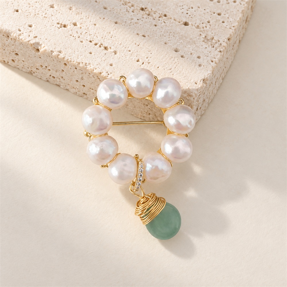 Close view of freshwater pearl wreath pin and green jade drop