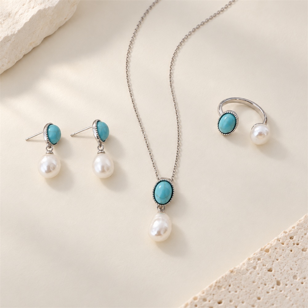 Turquoise and pearl three-piece jewelry set in a silver-tone finish, arranged flat