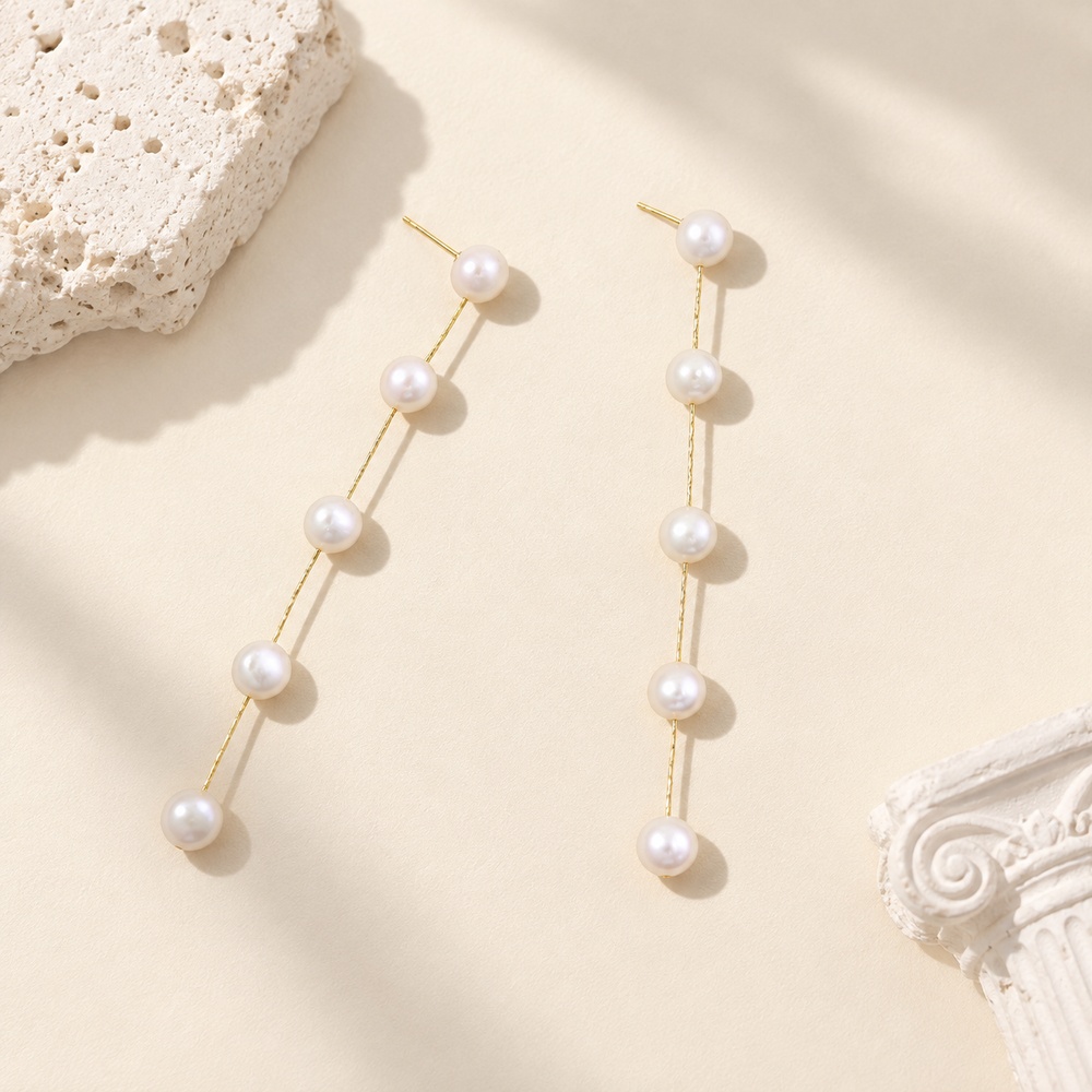 Gold-tone five-pearl linear drop earrings shown flat from the front