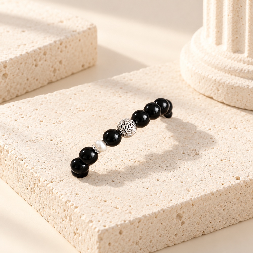 Obsidian stretch bracelet showing its pearl and silver-tone centre accents on stone
